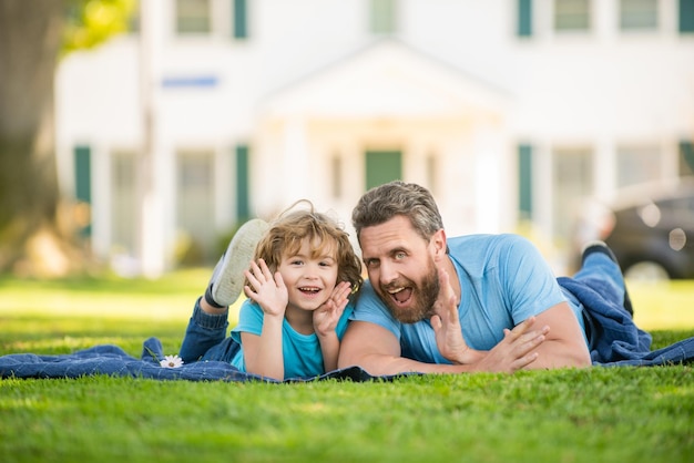 El valor familiar de la infancia y la paternidad se relaja con un niño pequeño en el césped