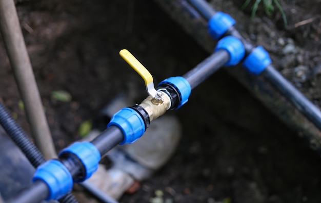 Válvula de água conectada ao tubo de PVC. Sistema de irrigação para conceito de campos