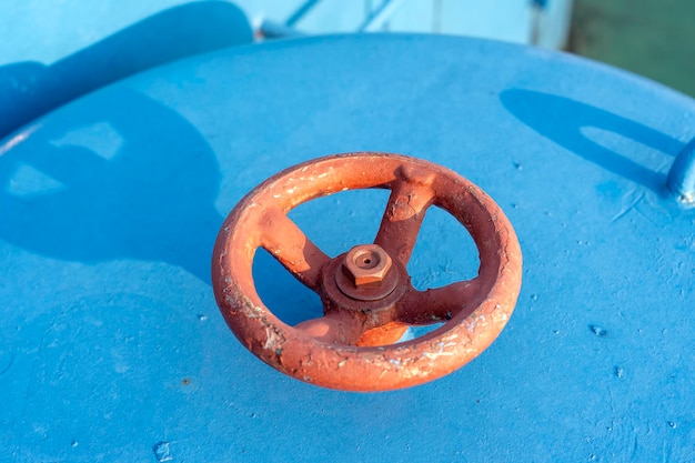 Válvula roja en el tubo azul Válvula con manija de rueda Engranaje industrial Primer plano
