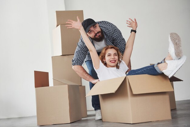 Vamos a divertirnos un poco. Pareja feliz juntos en su nueva casa. Concepción de mudanza