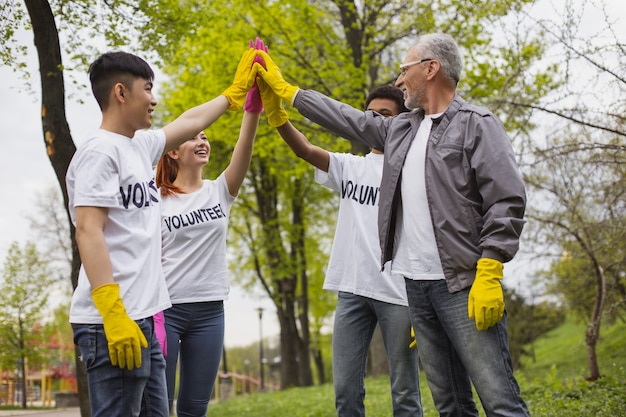 Vamos a hacerlo. Voluntarios gay positivos de pie e intercambiando cinco