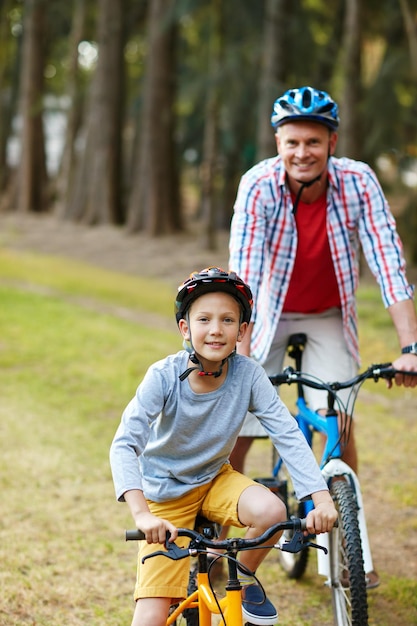 Vamos a montar Retrato de un padre y su hijo andando en bicicleta en un parque