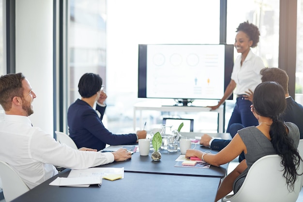 Vamos rever o ano foto recortada de uma empresária fazendo uma apresentação na sala de reuniões