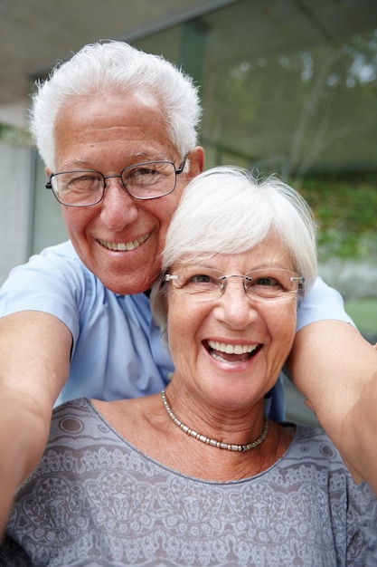 Vamos tirar uma para as crianças Foto de um casal de idosos posando para uma selfie