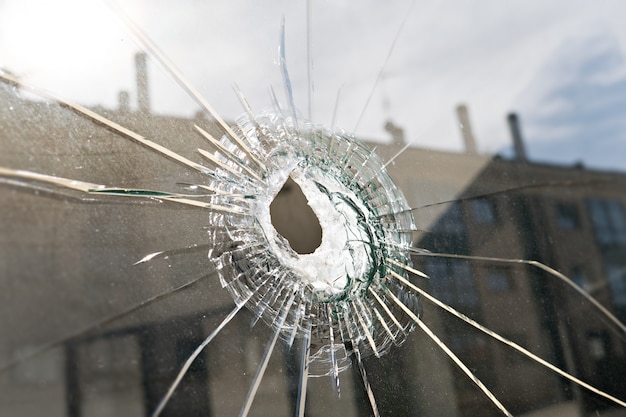 Foto vandalismus oder gewalt konzept. glasscherben mit loch