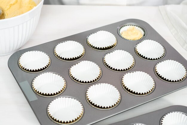 Foto vanille-cupcakes in einer cupcake-pfanne backen.