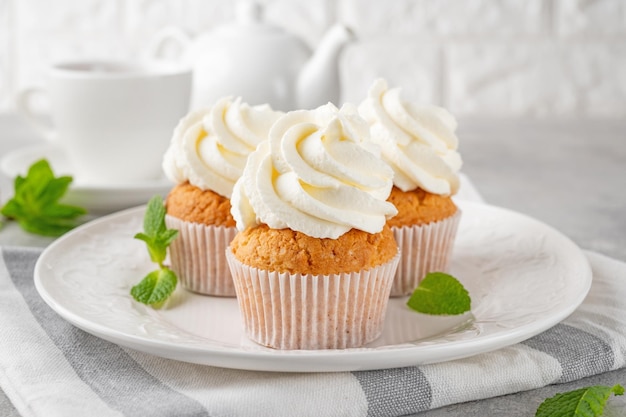 Vanille Cupcakes mit Frischkäse und Kandiszucker auf grauem Hintergrund Dessert zum Geburtstag