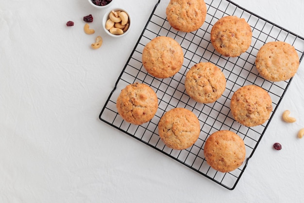 Vanille frisch gebackene Muffins auf einem weißen Tisch mit Nüssen und Beeren