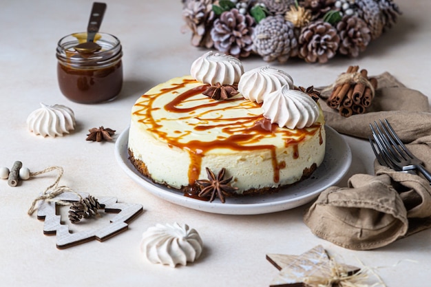 Vanille-Käsekuchen mit Karottenkuchen-Kruste, serviert mit salzigem Karamell-Topping und Baiser