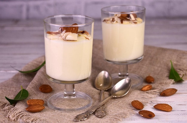 Vanille-Mousse-Pudding mit Mandeln auf Holzhintergrund.