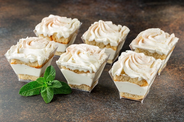 Vanille-Schichtdessert in einer Plastikbox auf dunklem Tisch