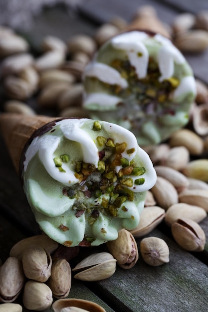 Vanilleeistüte mit Pistazien. Pistazien im Hintergrund.Nahaufnahme