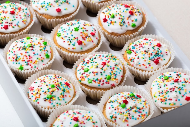 Vanillekleine kuchen mit weißer glasur, verpackung des kleinen kuchens, lieferungskasten, draufsicht