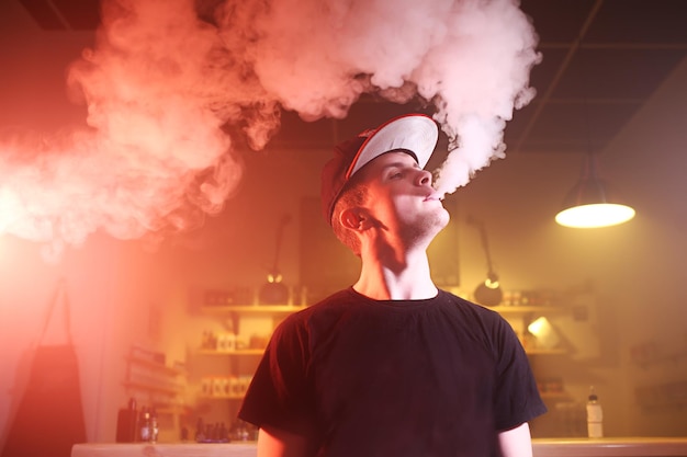 Vaping hombre en una nube de vapor en un bar vape