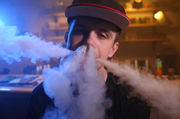 Vaping homem em uma nuvem de vapor em um bar vape closeup