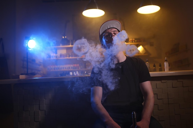 Vaping homem em uma nuvem de vapor em um bar vape