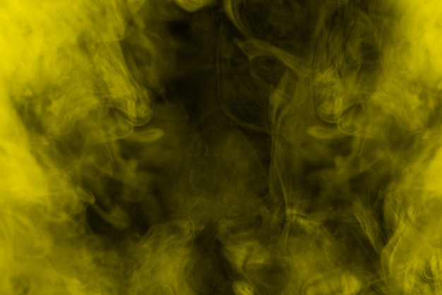 Vapor amarillo sobre fondo negro. Copie el espacio.