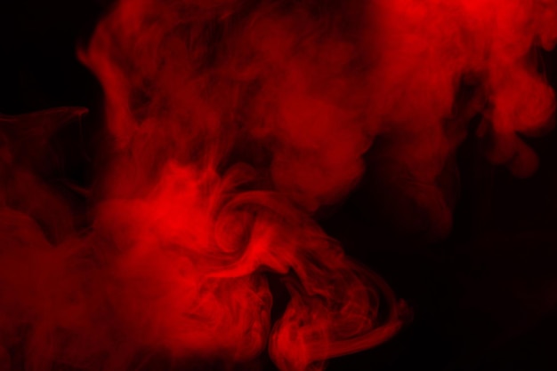 Vapor rojo sobre un fondo negro. Copie el espacio.