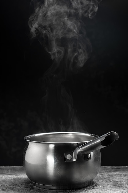 Vapor sobre olla sobre fondo negro Comida caliente Tazón de vapor caliente con humo Concepto de cocina culinaria