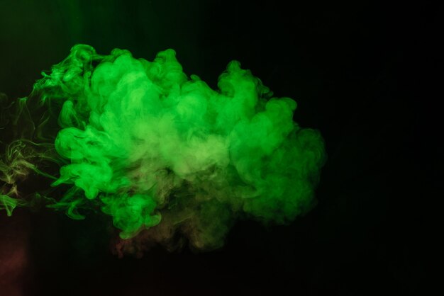 Vapor verde y rosa sobre una superficie negra