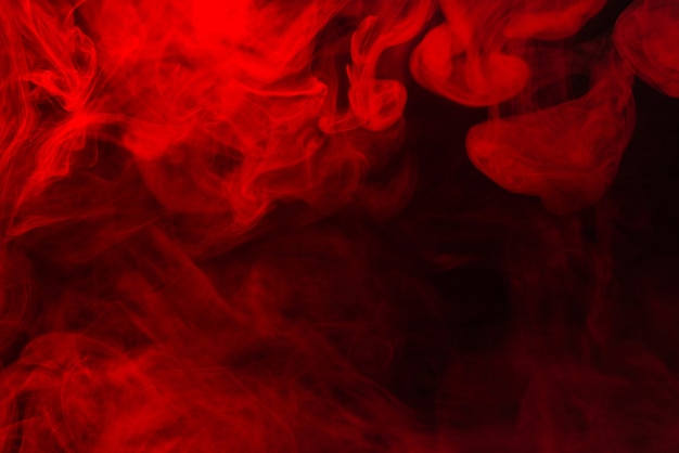 Vapor vermelho sobre um fundo preto. Copie o espaço.