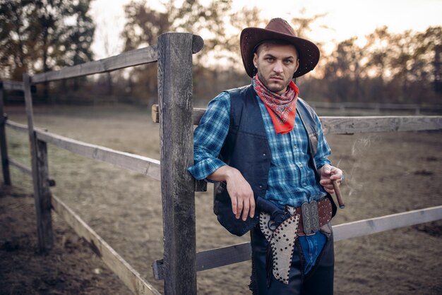 Vaquero brutal posa en el corral de caballos en el rancho