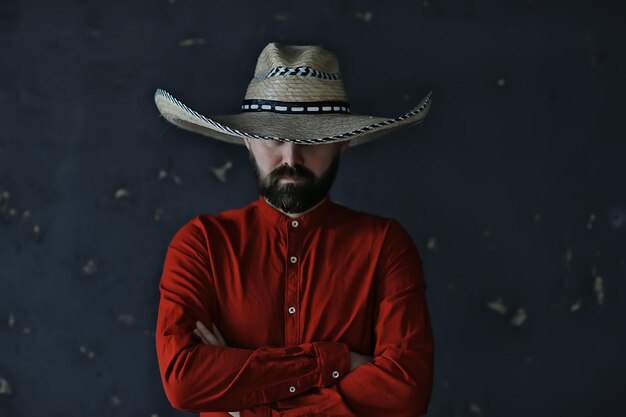 vaquero severo en un sombrero con ala, paja, estilo retro vintage, hombre enojado salvaje oeste occidental