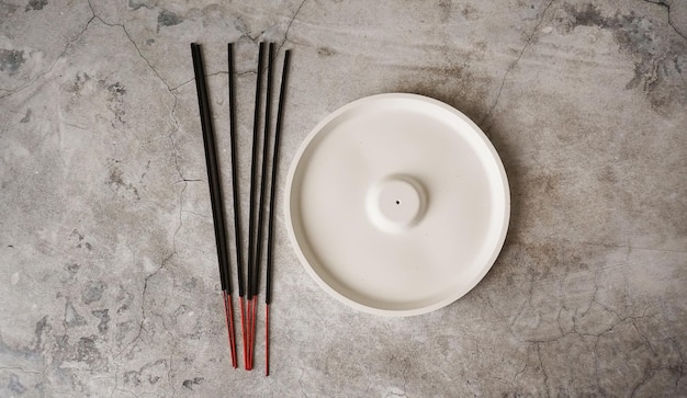 Vara de incenso em suporte de cerâmica artesanal de porcelana sobre mesa de mármore