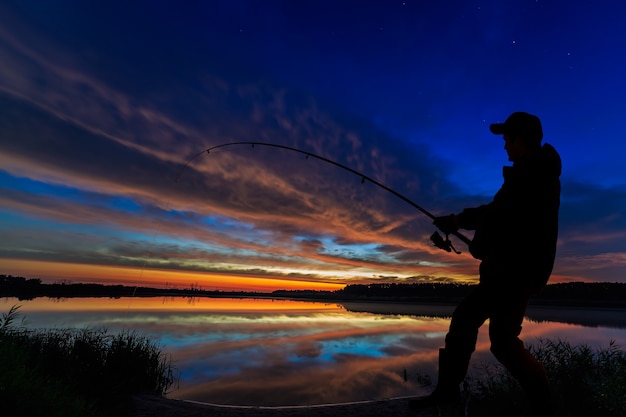 Foto vara de pesca do pescador ao amanhecer no lago.