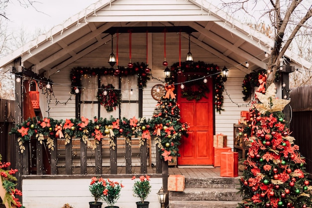 Varanda da casa com porta vermelha decorada de acordo com o ano novo