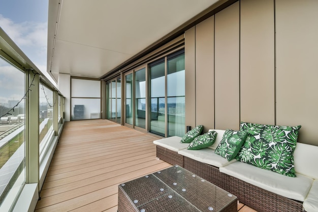 Varanda espaçosa com piso de madeira e cerca de vidro em estilo moderno