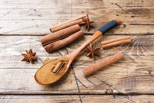 Varas de canela perfumadas das especiarias e terra, anis de estrela no fundo de madeira.