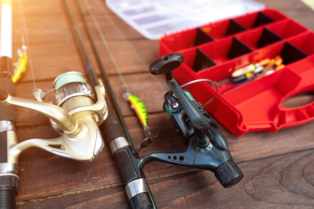 Varas de pesca e equipamento em um fundo de madeira