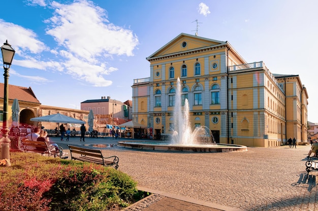 Varazdin, croácia - 1 de maio de 2019: praça com pessoas na fonte no teatro nacional na cidade velha de varazdin, na croácia. panorama e paisagem urbana da famosa cidade croata na europa no verão.