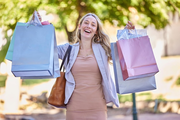 Varejo de compras e retrato de mulher com sacola de compras andando na rua da cidade e calçada com sorriso Riqueza de shopping e viciada em compras com produtos de desconto de venda e barganha na loja