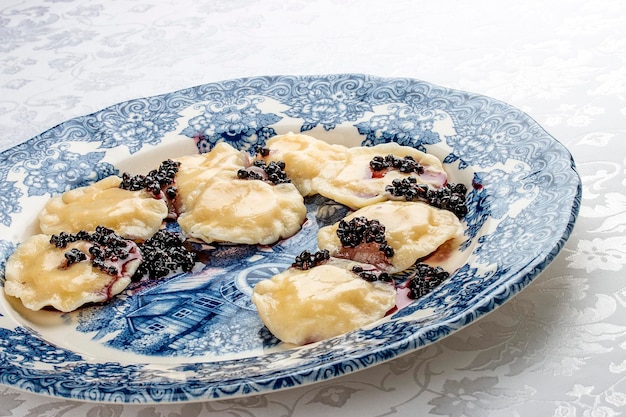 Vareniki mit Ricotta-Käse und Holunderbeeren auf einem dekorativen Teller