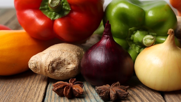 Variação de ingredientes cebolagarlicginger tomilhopimenta e ervas em uma mesa de cozinha de madeira Composição com vegetais crus Banner