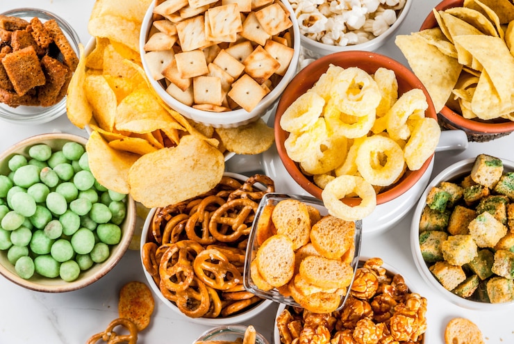 Foto variação diferentes biscoitos salgadinhos insalubres, pipoca salgada doce, tortilhas, nozes, palhas, bretsels