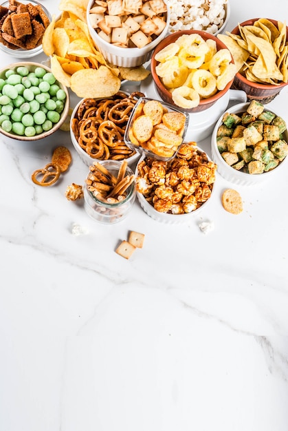 Foto variação diferentes biscoitos salgadinhos insalubres, pipoca salgada doce, tortilhas, nozes, palhas, bretsels