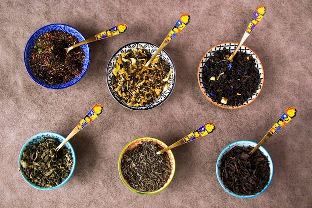 Foto variación de juegos de té seco a base de hierbas y naturales y colección de cucharas de té y vintage