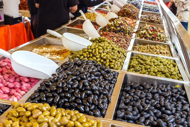 Varias aceitunas marinadas en venta en una ventana de mercado