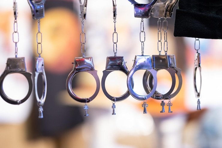 Foto várias algemas de aço suspensas com pequenas chaves em um fundo desfocado