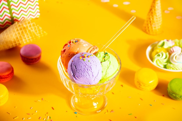 Varias bolas de helado de colores o un plato de sundae de bolas con macarrones de conos de galleta