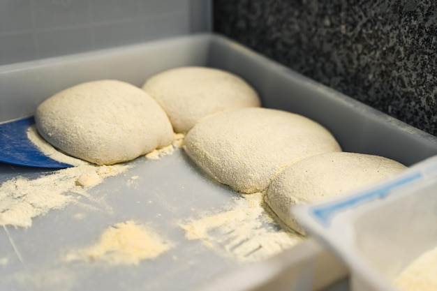 Varias bolas de masa de pizza juntas en la cocina preparando platos italianos