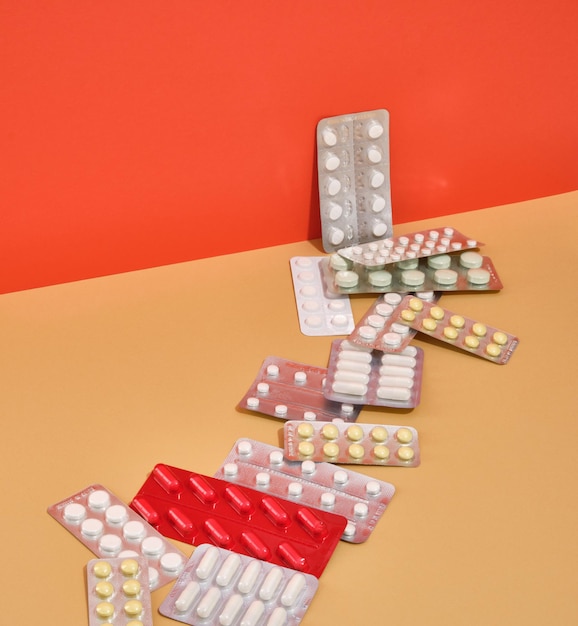 Várias bolhas de cápsulas de comprimidos e vitaminas foram espalhadas na mesa Negócios de saúde