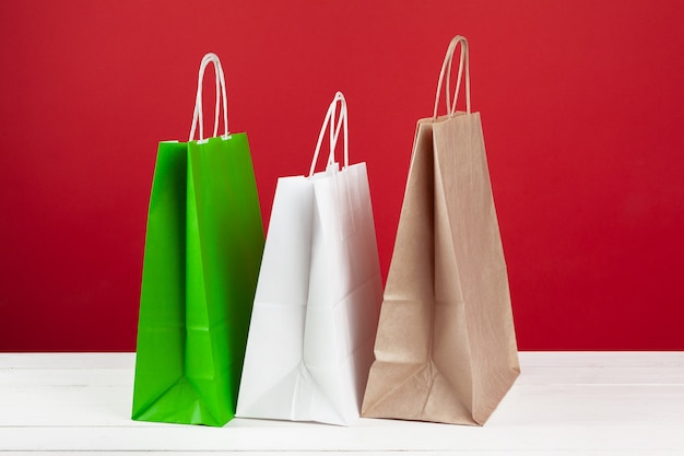 Varias bolsas de la compra con espacio de copia sobre fondo rojo.