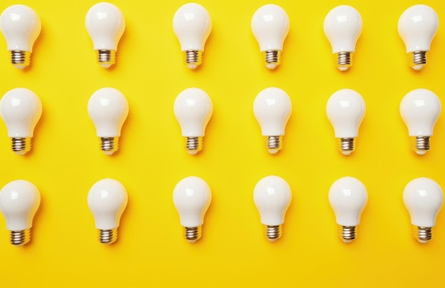 Varias bombillas en fondo amarillo concepto de ideas de negocio y creatividad IA generativa
