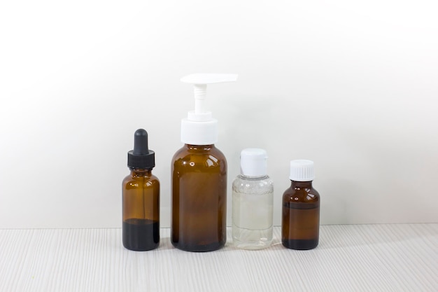 Foto varias botellas de vidrio para aceites esenciales cosméticos u otros líquidos aislados en un fondo blanco