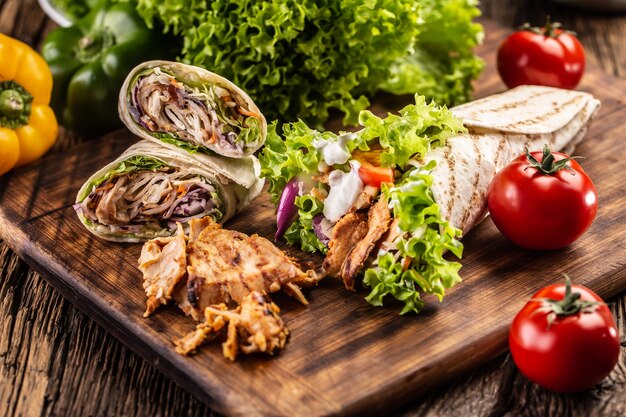 Foto varias comidas de tortilla en una tabla de cortar de madera.