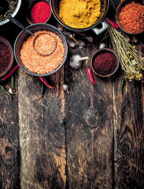 Varias especias y hierbas aromáticas en la mesa de madera.